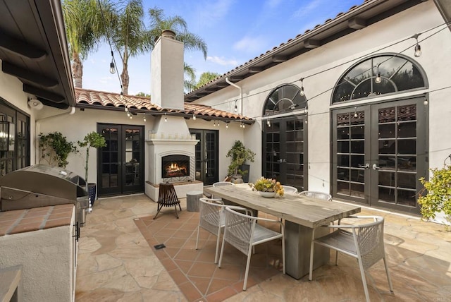 17182 Camino Acampo, Rancho Santa Fe, CA 92067 - view of patio / terrace with outdoor dining area, french doors, a warm lit fireplace, and a grill