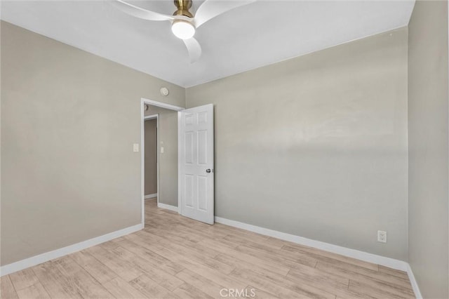 empty room featuring ceiling fan, baseboards, and light wood-style floors