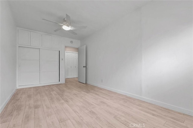 unfurnished bedroom with baseboards, ceiling fan, and light wood finished floors