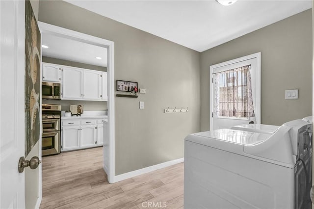 laundry area with laundry area, baseboards, recessed lighting, separate washer and dryer, and light wood finished floors