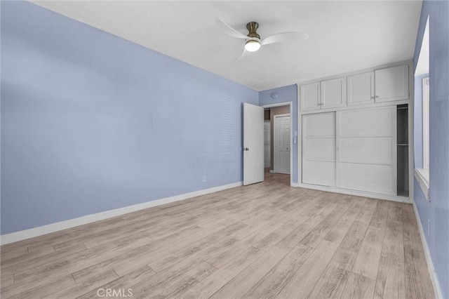 unfurnished bedroom featuring baseboards, ceiling fan, and light wood-style floors
