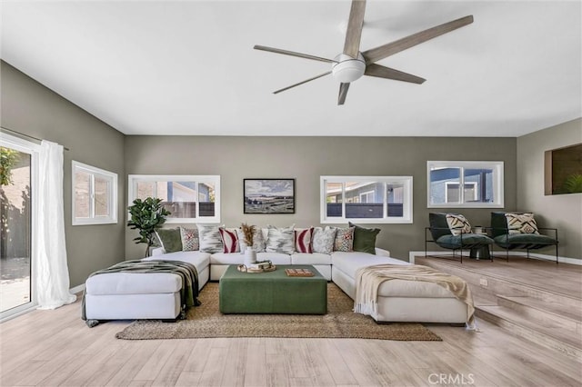 living room with plenty of natural light, a ceiling fan, and wood finished floors