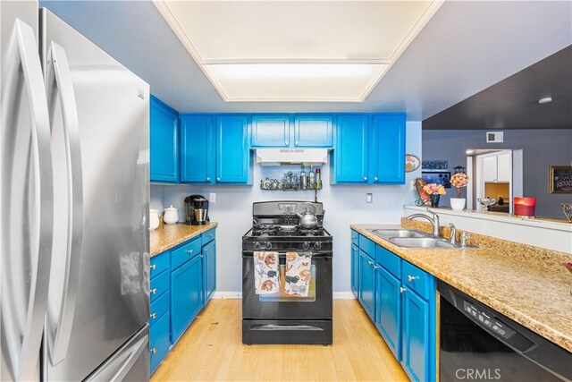 kitchen with under cabinet range hood, blue cabinetry, a sink, and black appliances