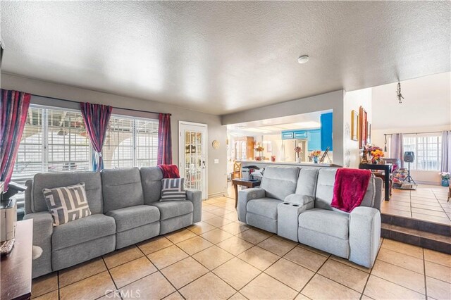 living room featuring a textured ceiling and light tile patterned floors