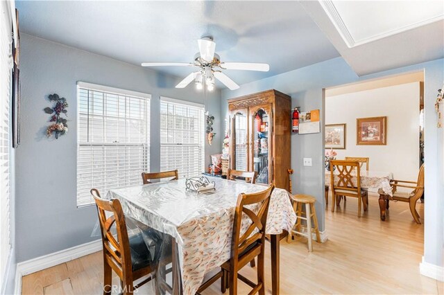 dining space featuring a ceiling fan, baseboards, and light wood-type flooring