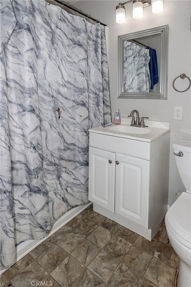 bathroom featuring vanity, toilet, and a shower with shower curtain
