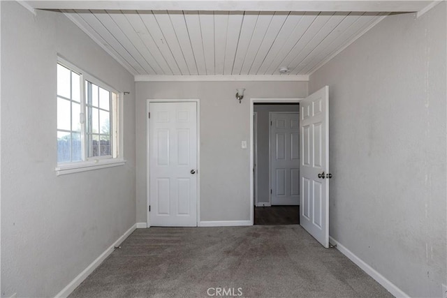 unfurnished bedroom featuring crown molding, baseboards, and carpet floors