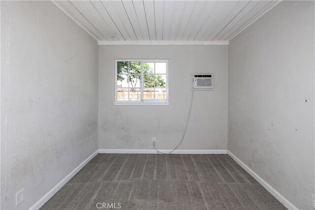 unfurnished room featuring wood ceiling, baseboards, a wall unit AC, and carpet flooring