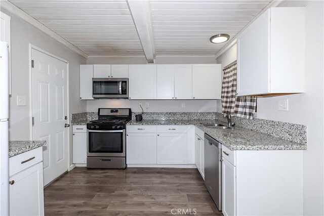 kitchen with a sink, beamed ceiling, white cabinets, and stainless steel appliances
