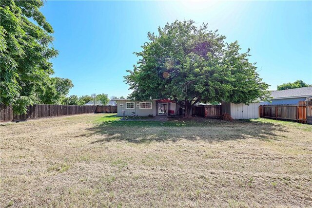 view of yard featuring a storage shed, an outbuilding, and a fenced backyard