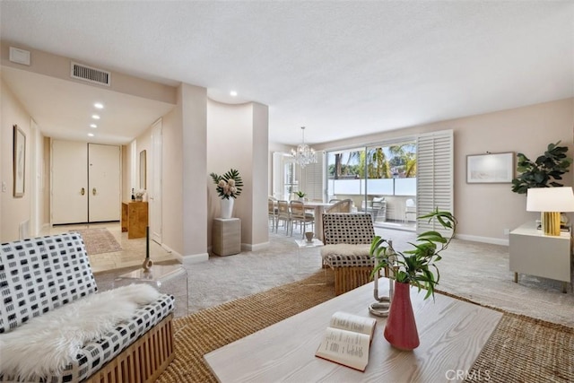 living room featuring carpet floors, a chandelier, baseboards, and visible vents