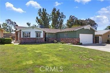 ranch-style home featuring driveway, a front yard, brick siding, and an attached garage