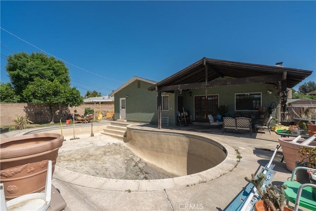 back of house featuring a patio area, stucco siding, and an outdoor living space