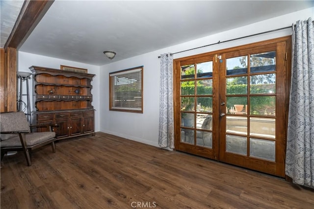 unfurnished room with wood finished floors, healthy amount of natural light, and baseboards