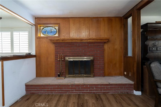 unfurnished living room featuring a fireplace, wood finished floors, and baseboards
