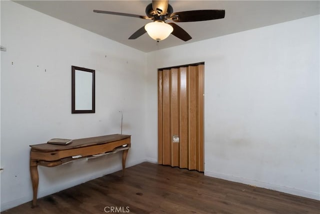spare room featuring wood finished floors, ceiling fan, and baseboards