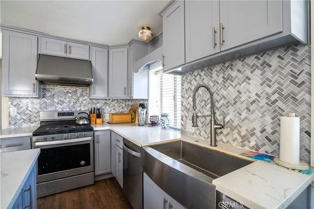9810 Sharon Ave, Riverside, CA 92503 - kitchen featuring appliances with stainless steel finishes, under cabinet range hood, gray cabinetry, and tasteful backsplash