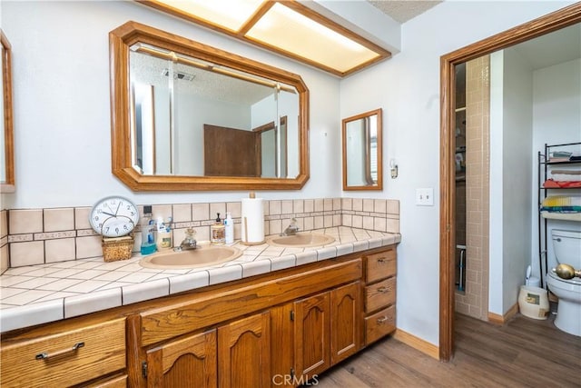 9810 Sharon Ave, Riverside, CA 92503 - full bath with wood finished floors, double vanity, and decorative backsplash