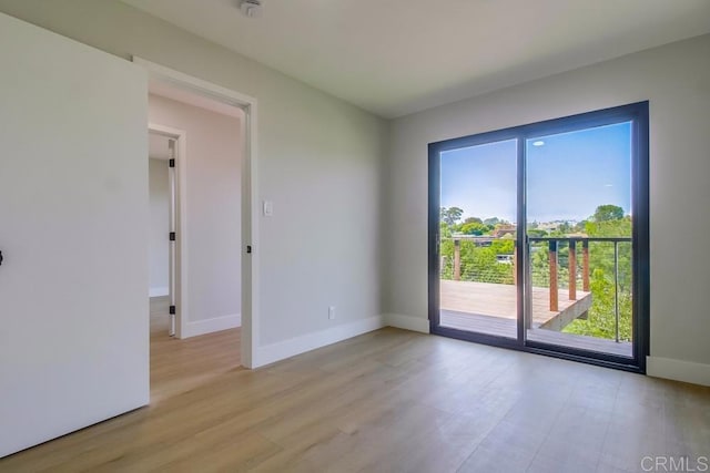 empty room featuring baseboards and light wood finished floors