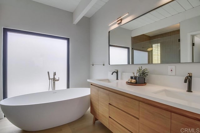full bathroom with double vanity, beam ceiling, a sink, and a soaking tub