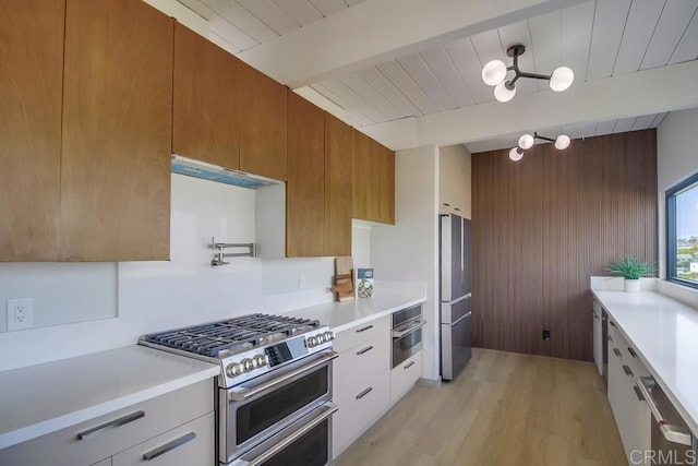 kitchen with light countertops, appliances with stainless steel finishes, and beamed ceiling