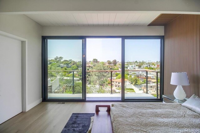 bedroom featuring visible vents, wood finished floors, and multiple windows