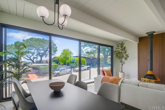 936 Bangor St, San Diego, CA 92106 - dining area with a wood stove, beamed ceiling, and wood walls