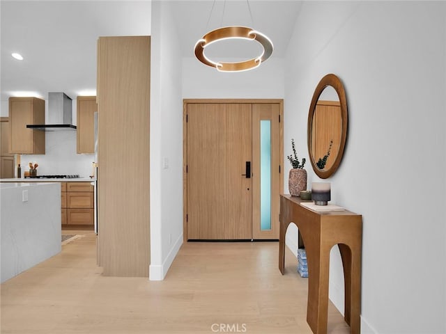 foyer entrance featuring recessed lighting, baseboards, a high ceiling, and light wood-style floors