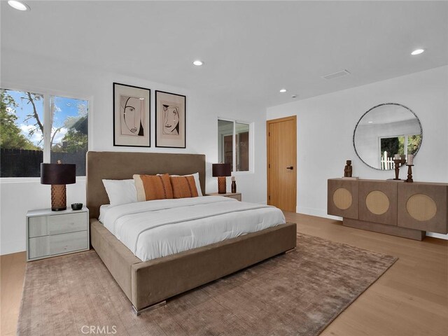 bedroom with recessed lighting, wood finished floors, and visible vents