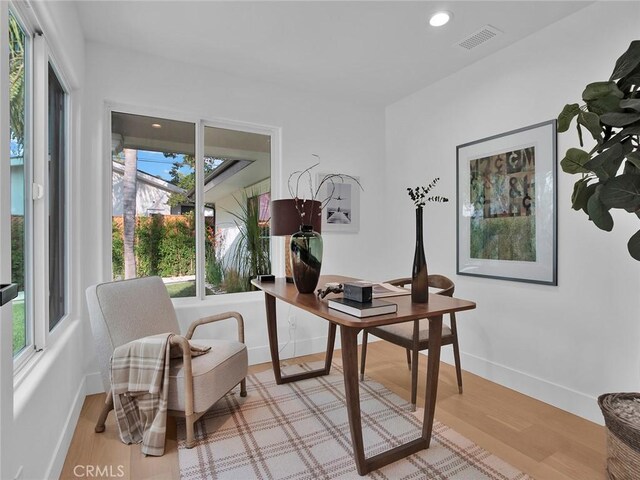 office featuring baseboards, visible vents, and a wealth of natural light