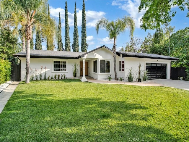 view of front facade featuring a garage, stucco siding, a front yard, and concrete driveway