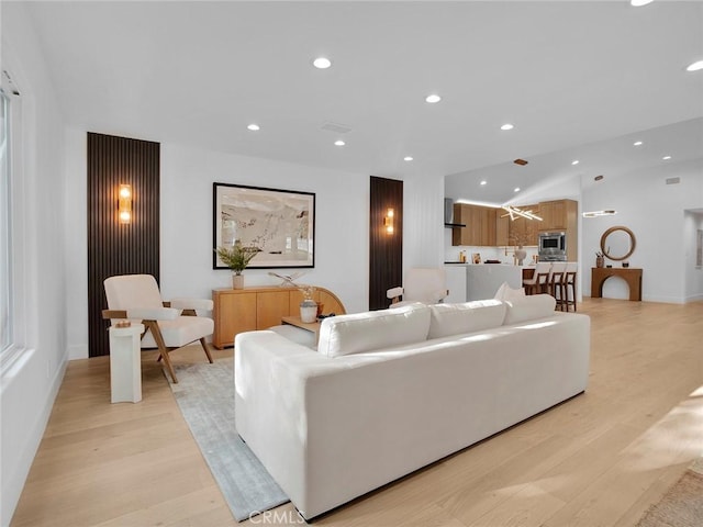 living area featuring recessed lighting, light wood-style flooring, and lofted ceiling