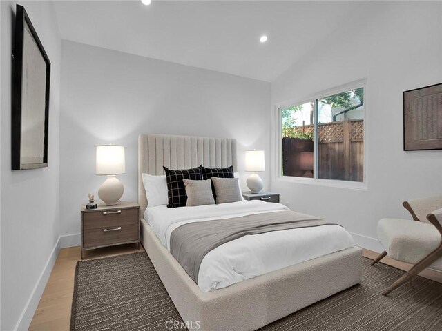 bedroom featuring recessed lighting, baseboards, vaulted ceiling, and wood finished floors