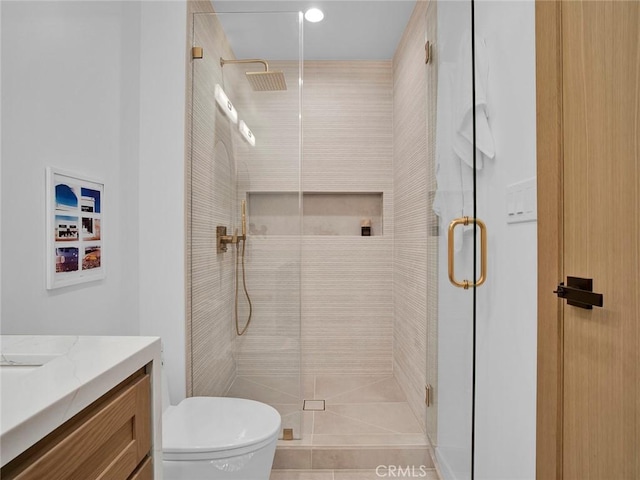 bathroom featuring vanity, toilet, and a stall shower