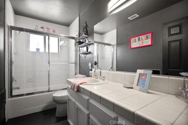 13784 Choco Rd, Apple Valley, CA 92307 - full bath featuring tile patterned floors, vanity, toilet, and enclosed tub / shower combo