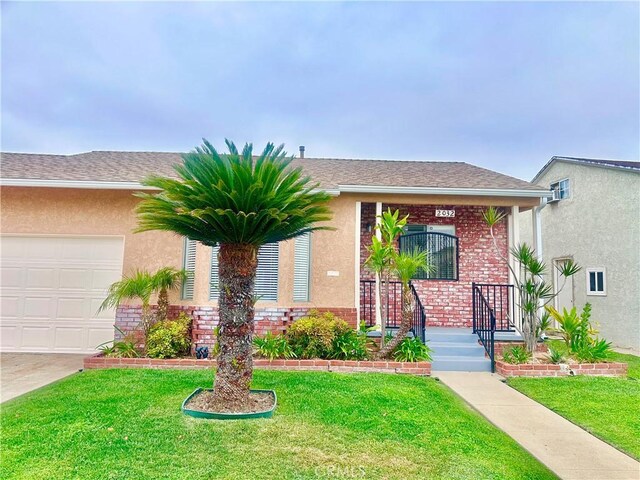 ranch-style home featuring brick siding, an attached garage, a front yard, and stucco siding