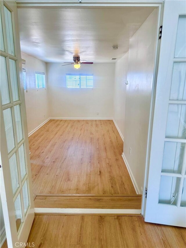 unfurnished room featuring baseboards, ceiling fan, and wood finished floors