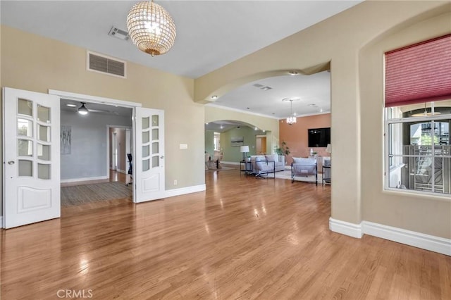 9371 Florence Ave, Downey, CA 90240 - unfurnished living room featuring arched walkways, visible vents, baseboards, and a chandelier