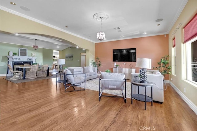9371 Florence Ave, Downey, CA 90240 - living room with arched walkways, a chandelier, a wealth of natural light, and light wood finished floors