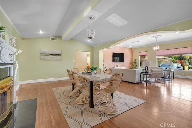 9371 Florence Ave, Downey, CA 90240 - dining area featuring visible vents, arched walkways, wood finished floors, a chandelier, and vaulted ceiling with beams