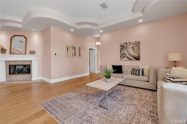 9371 Florence Ave, Downey, CA 90240 - living area with a tiled fireplace, recessed lighting, baseboards, wood finished floors, and a tray ceiling
