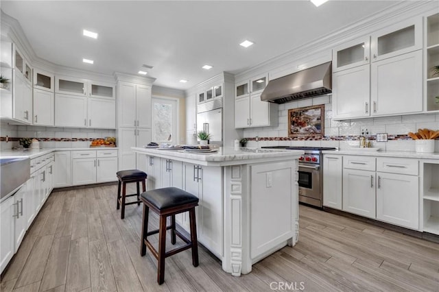 9371 Florence Ave, Downey, CA 90240 - kitchen featuring decorative backsplash, high quality appliances, open shelves, light wood-style floors, and wall chimney exhaust hood