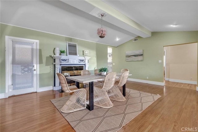 9371 Florence Ave, Downey, CA 90240 - dining space with visible vents, wood finished floors, a fireplace, baseboards, and lofted ceiling with beams