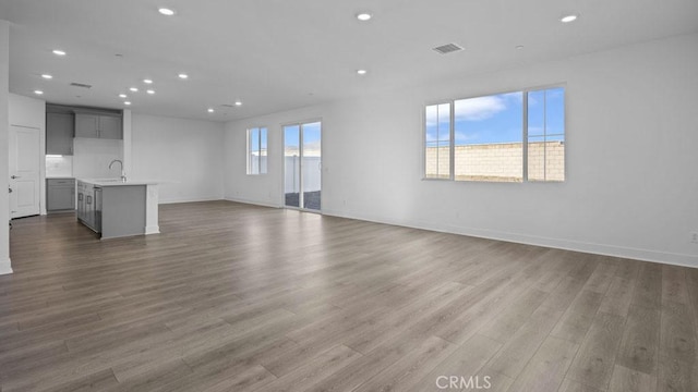 33328 Rusty Ct, French Valley, CA 92596 - unfurnished living room with visible vents, recessed lighting, baseboards, and wood finished floors