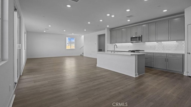 33328 Rusty Ct, French Valley, CA 92596 - kitchen with open floor plan, stainless steel microwave, backsplash, and gray cabinetry