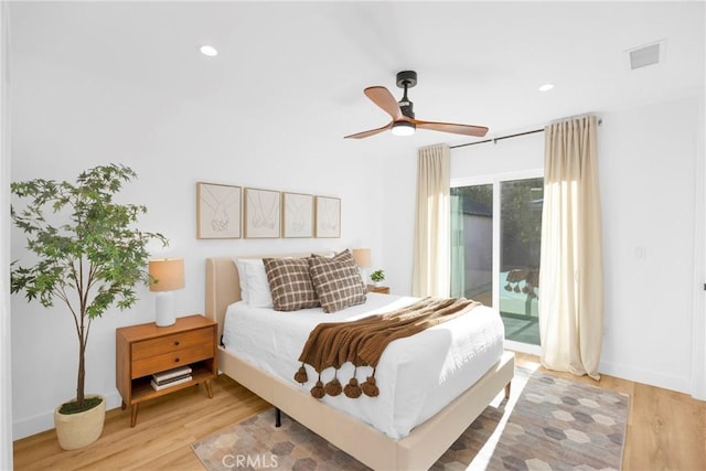 bedroom with access to outside, recessed lighting, wood finished floors, and visible vents