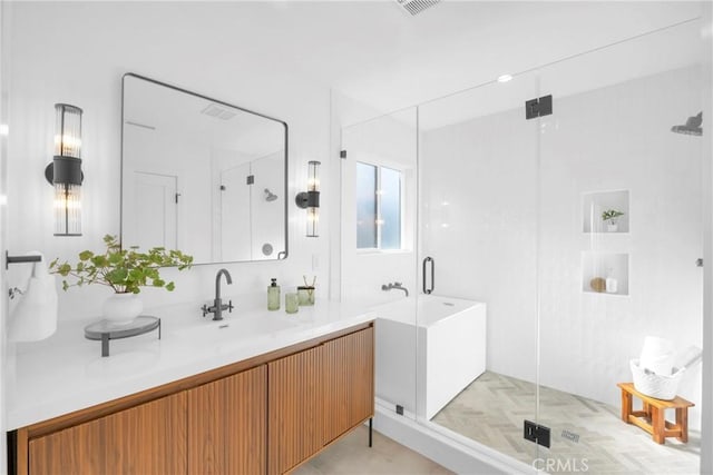 full bath featuring vanity, a bathing tub, a stall shower, and visible vents