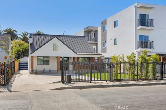 view of front of property featuring a gate, a fenced front yard, and stucco siding