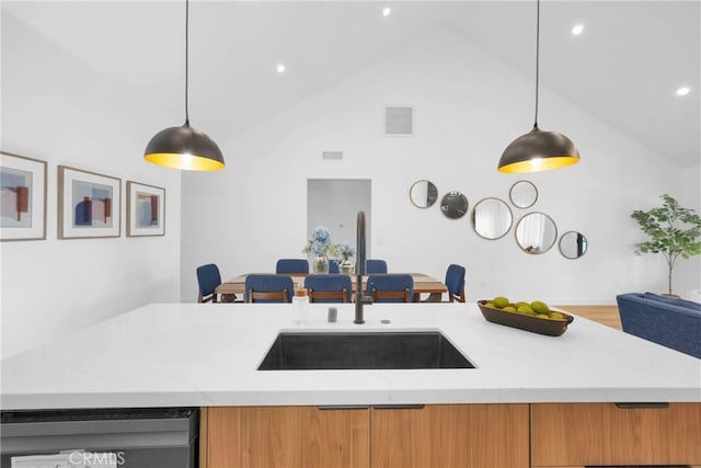 kitchen featuring visible vents, a sink, high vaulted ceiling, light stone counters, and dishwashing machine