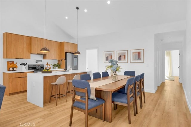 dining area with recessed lighting, light wood-style flooring, baseboards, and vaulted ceiling